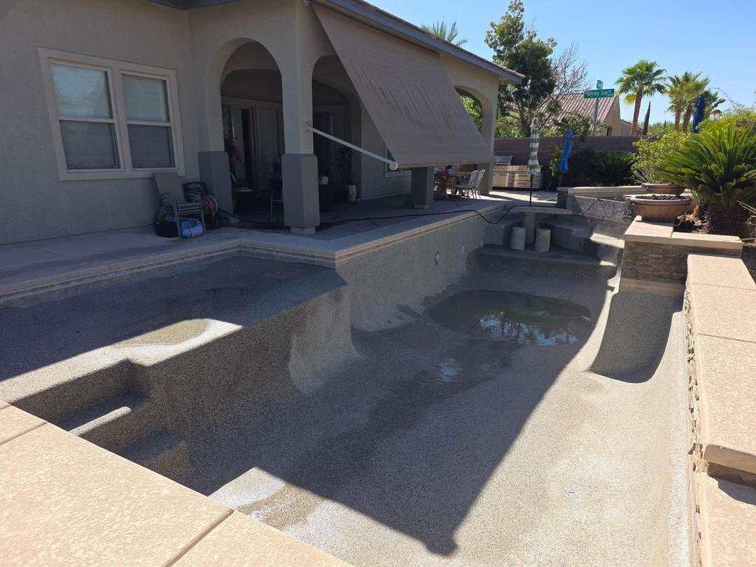 Drained pool and spa with a pebble finish, ready for cleaning