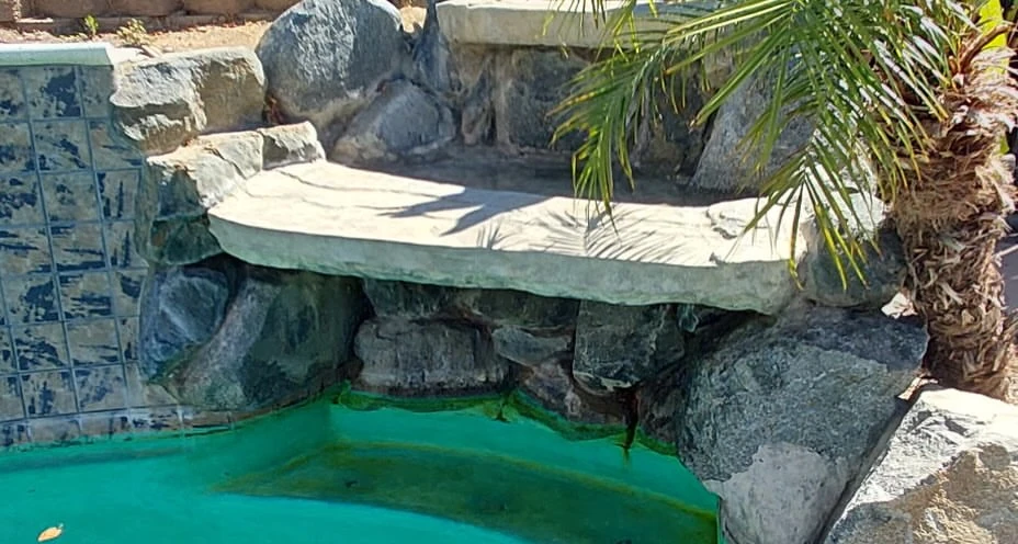 Rock waterfall and spa with green water