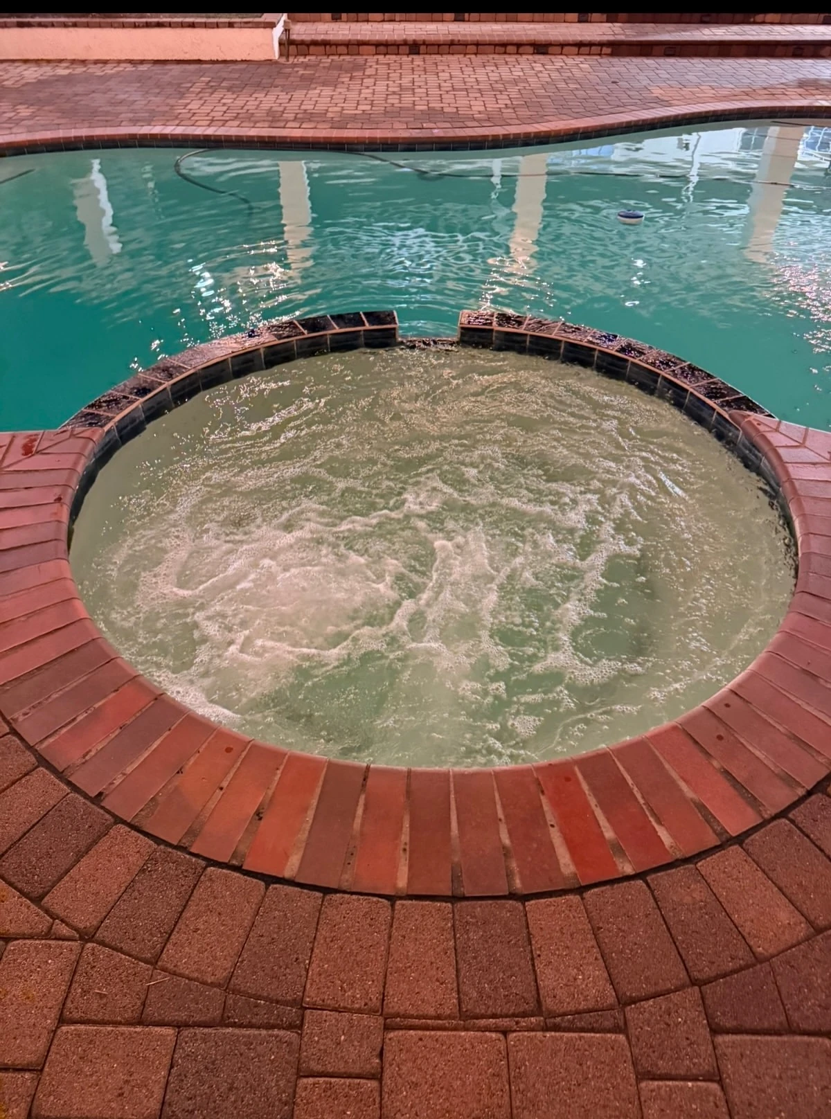Raised spa with brick coping during a spa cleaning